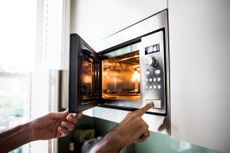 Image of someone opening a microwave.